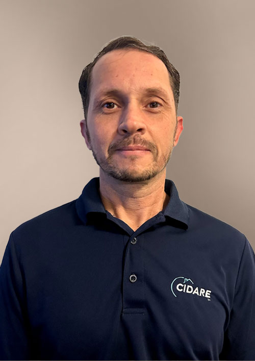 Hakim Boulil is a white man with brown hair and a beard, wearing a jacket and he's smiling.